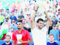 Grigor Dimitrov levanta su trofeo de campeón; al fondo, su rival en la Final, Nick Kyrgios, sostiene el premio de segundo lugar. AFP /