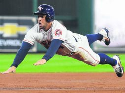 George Springer de los Astros se desliza con seguridad a la tercera almohadilla con el sencillo de Alex Bregman. AP /