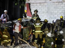 Bomberos y voluntarios trabajan entre los escombros para encontrar sobrevivientes. AFP / R. Schemidt