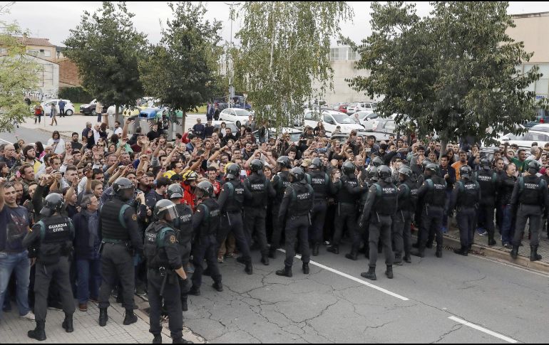 Un grupo de personas protesta en el centro de votación en Girona. EFE / A. Dalmau