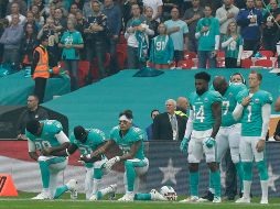 Julius Thomas (I), Michael Thomas (C) y Kenny Stills (D) se arrodillan en el estadio de Wembley durante la ceremonia del himno estadounidense previa al partido contra los Santos. AP/ M. Dunham