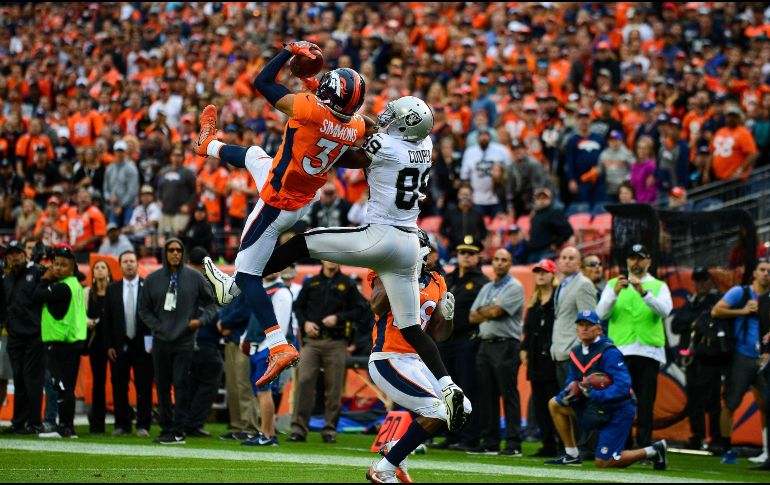 Simmons (I), de los Broncos, intercepta un pase dirigido a Amari Cooper (D), de los Raiders.AFP/ D. Brradford