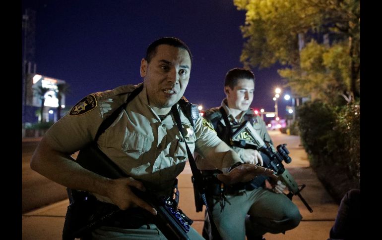 Policías piden a personas en una calle que se resguarden AP/J.Locher