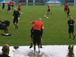 Sin mojarse. El estadounidense Michael Bradley es cargado al campo de entrenamiento en Couva para que no toque el agua. AP