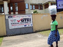 Una mujer pasa frente a una pancarta donde se lee 