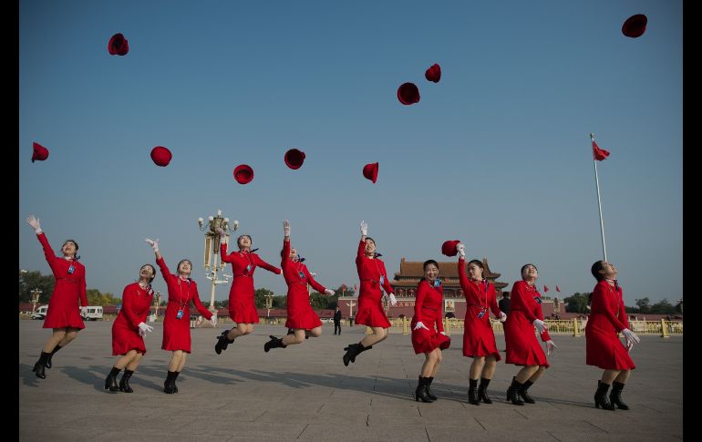 Edecanes saltan en la plaza Tiananmen durante el cierre del congreso del Partido Comunista chino en Pekín. AFP/N. Asfouri