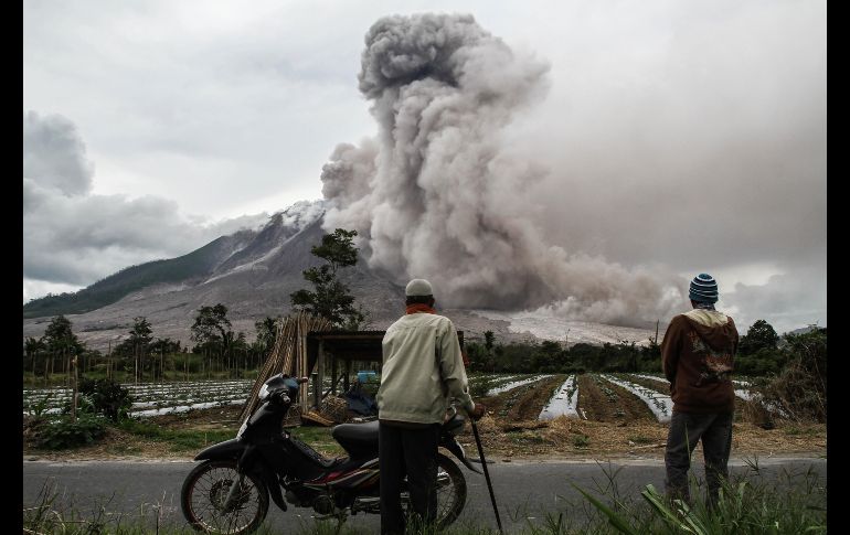 Pobladores observan una erupción del volcán Sinabung en Karo, Indonesia. AFP/I. Damanik