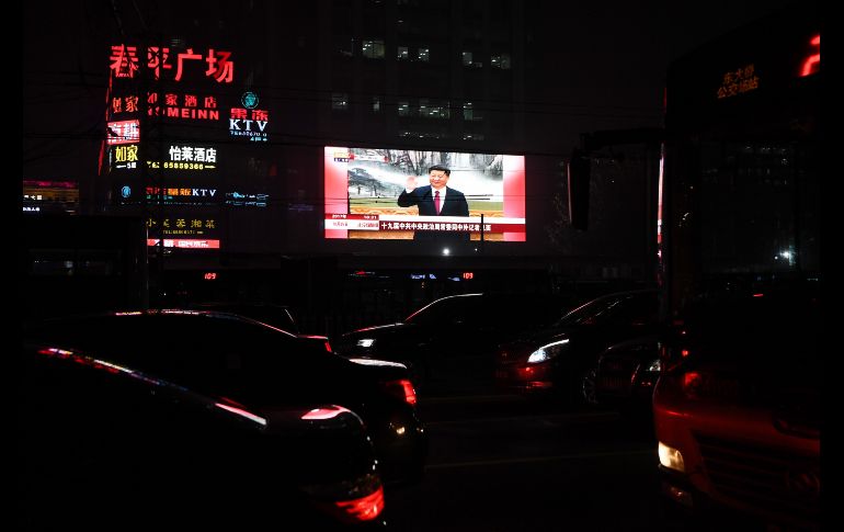 Una pantalla muestra noticias sobre el presidente de China,  Xi Jinping, en Pekín. El mandatario recibió este miércoles un segundo mandato de cinco años como líder del Partido Comunista. AFP/G. Baker