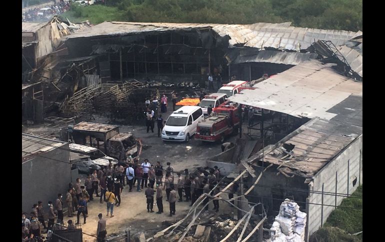 Policías y rescatistas inspeccionan el sitio donde se registró la explosión de una fábrica de cohetes, a las afueras de Jakarta, Indonesia. AP/T. Syuflana
