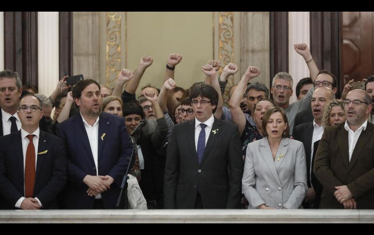 El presidente de la Generalitat, Carles Puigdemont (centro) junto al vicepresidente del Govern y conseller de Economía, Oriol Junqueras y la presidenta del Parlament, Carme Forcadell , junto a diputados de la CUP, en las escalinatas del Parlament tras aprobarse en el pleno la declaración de independencia. EFE / A. Dalmau
