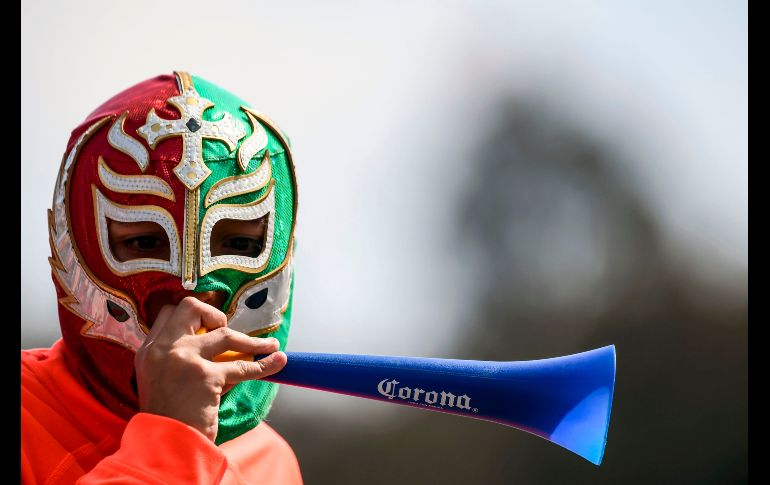 Un aficionado asiste con una máscara de luchador.