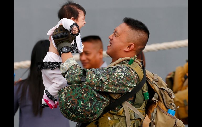 El marino filipino Reginald Dangani levanta a su bebé de cuatro meses tras desembarcar en Manila, a su regreso del operativo para combatir a militantes del Estado Islámico en Marawi, donde se declaró el fin de los combates. AP/B. Marquez
