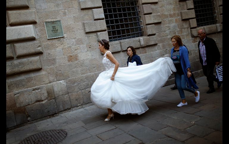 Una novia camina junto al Parlamento catalán. Los empleados públicos asumieron hoy la nueva situación en Cataluña, después de que el Gobierno español cesara al Ejecutivo regional y disolviera su Parlamento. AP/F. Seco