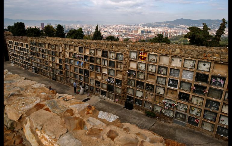 Personas limpian una tumba en el panteón Montjuic de Barcelona, en el marco del Día de todos los santos. AP/M. Fernández