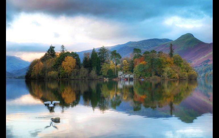 Árboles en tonos otoñales se reflejan en un lago en Keswick, en el norte de Inglaterra. AP/PA/O. Humphreys