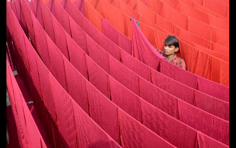 Un artesano pone chales a secar tras aplicarles colorante en Amritsar, India. AFP/N. Nanu