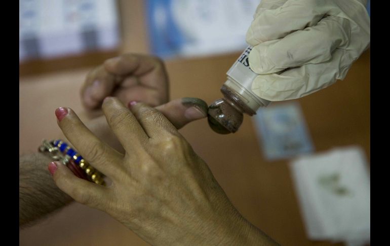 Un miembro de las juntas receptoras de votos pinta con tinta indeleble el dedo de un ciudadano después de votar en Managua, Nicaragua, en la jornada de elecciones de alcaldes, vicealcaldes y concejales. EFE/J. Torres