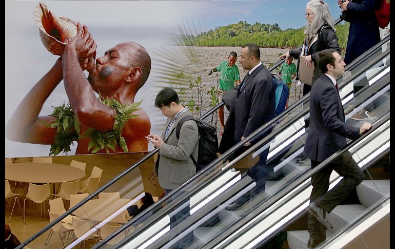 Delegados asistentes a la Conferencia del Cambio Climático pasan por un póster de las islas Fiji en Bonn, Alemania. AP/DPA/O. Berg