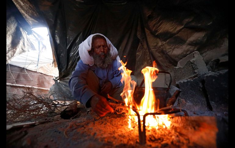 Un palestino prepara una bebida caliente en una cueva, que usa de hogar, en un poblado cerca de la ciudad de Yatta. Los residentes de la zona aseguran que no se pueden construir casas ni carreteras ante la prohibición del ejército. EFE/ A. Al Hashlamoun