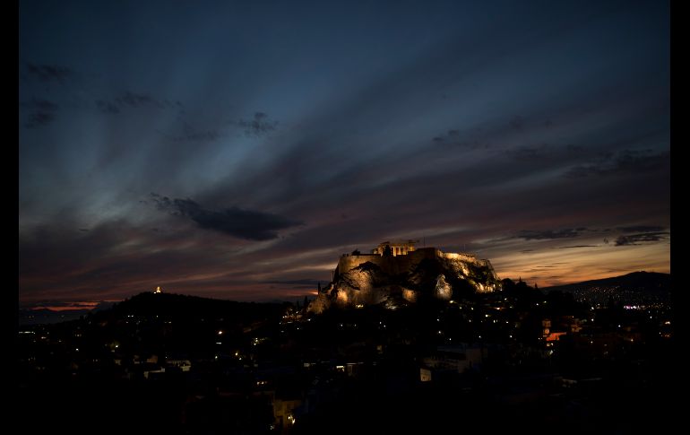 El Sol se pone detrás de la antigua Acrópolis y las ruinas del templo del Partenón en Atenas. AP/P. Giannakouris
