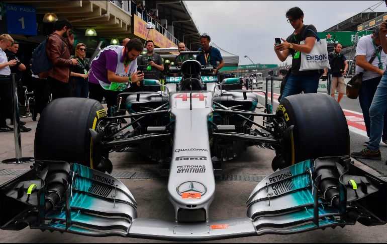 Aficionados que se dieron cita ayer en el Autódromo José Carlos Pace, aprovecharon para tomar fotografías del monoplaza del británico Lewis Hamilton. AFP/N. Almeida