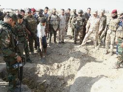 Cuerpos. Fuerzas iraquíes inspeccionan la zona de una fosa clandestina atribuida a los radicales del Estado Islámico, en el Distrito de Hawija. AFP