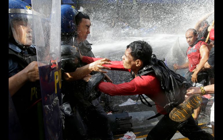 Manifestantes se enfrentan con policías cerca de la Embajada estadounidense en Manila. Trump llegó hoy a Filipinas para participar en la cumbre de la Asociación de Naciones del Sudeste Asiático (ASEAN).