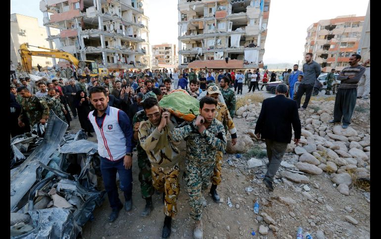 Miembros de la Media Luna Roja de Irán y los servicios de rescate cargan con el cuerpo de una de las víctimas en Pole-Zahab.