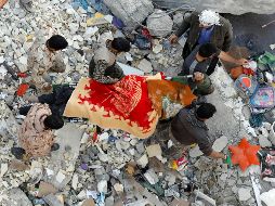 Servicios de rescate cargan con el cuerpo de una de las víctimas rescatado entre los escombros de un edificio de Pole-Zahab, en la provincia de Kermanshah. EFE/A. Taherkenareh