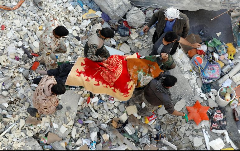 Servicios de rescate cargan con el cuerpo de una de las víctimas rescatado entre los escombros de un edificio de Pole-Zahab, en la provincia de Kermanshah. EFE/A. Taherkenareh