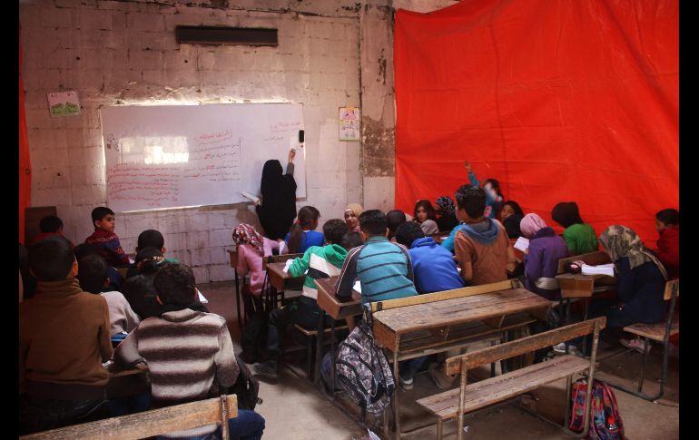Sirios desplazados asisten a una clase en una escuela hechiza dentro a la zona de rebeldes, en Daraa. AFP/M. Abazeed