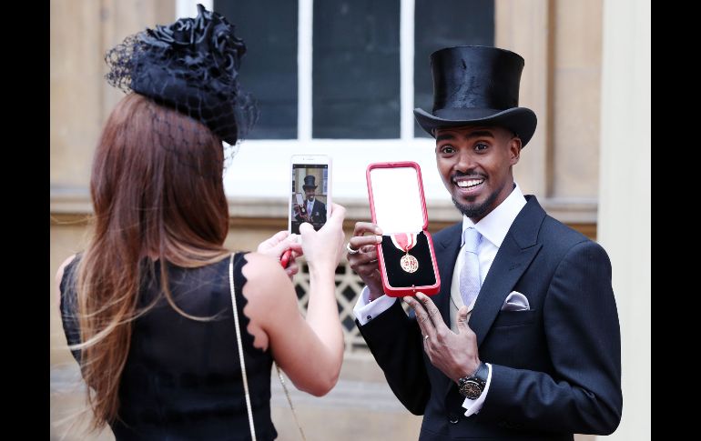 El corredor británico Mo Farah posa con su medalla tras ser nombrado caballero, durante una ceremonia de investidura en el Palacio de Buckingham, en Londres. AFP/PA/J. Brady
