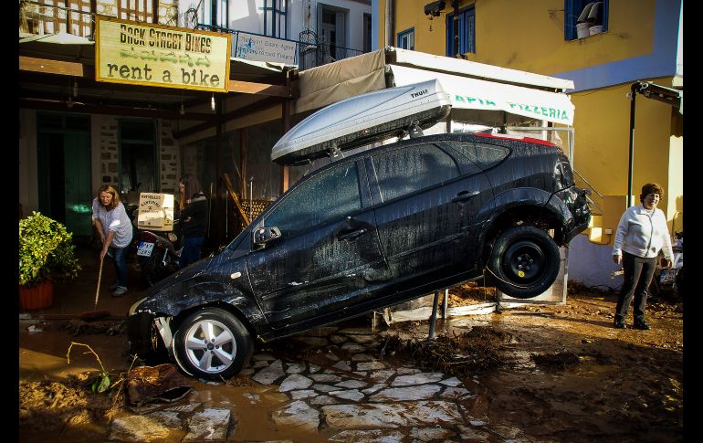 Personas en un negocio de renta de autos limpian tras los daños provocados tras inundaciones en la isla griega de Symi. Autoridades declararon el estado de emergencia tras los estragos por una fuerte tormenta. AP /Eurokinissi/A. Madikos