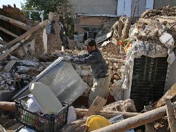 Un hombre rescata sus pertenencias de su hogar, que se derrumbó tras el terremoto. AP/A. Salemi