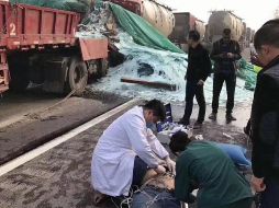 Equipos de rescate atienden a uno de los heridos; al fondo, se pueden ver varios de los autos participantes en el accidente. TWITTER