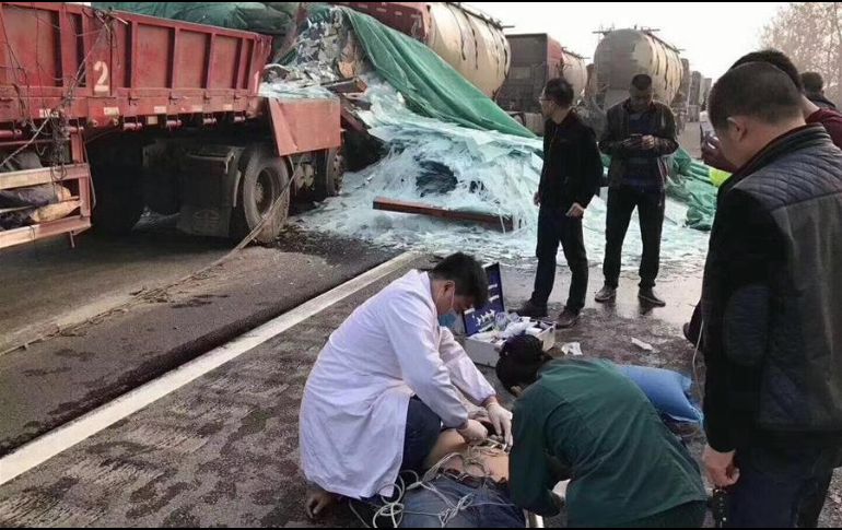 Equipos de rescate atienden a uno de los heridos; al fondo, se pueden ver varios de los autos participantes en el accidente. TWITTER