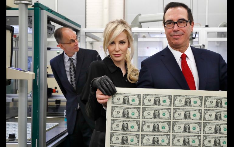 El secretario del Tesoro de EU, Steven Mnuchin (d) y su esposa Louise Linton con una hoja de los nuevos billetes de un dólar en la Oficina de Grabado e Impresión de Washington. Los billetes llevan la firma de Mnuchin y la tesorera Jovita Carranza. AP/J. Martin