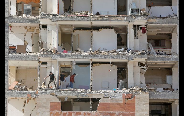 Personas caminan en un edificio en Sarpol-e Zahab, Irán, dañado por el sismo de magnitud 7.3. AFP/A. Kenare