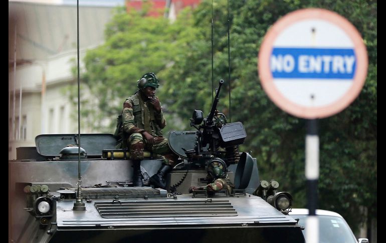 Soldados vigilan en un calle de Harare, Zimbabue. El presidente Robert Mugabe se resiste a presentar la dimisión como parte de las negociaciones con los militares, que lo mantienen detenido en su casa. AP
