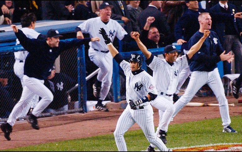 Aaron Boone levanta su mano derecha después de dejar tendidos en el terreno a los Medias Rojas de Boston en 16 de octubre de 2003 para que los Yankees avanzaran a la Serie Mundial. AP/B. Kostroun