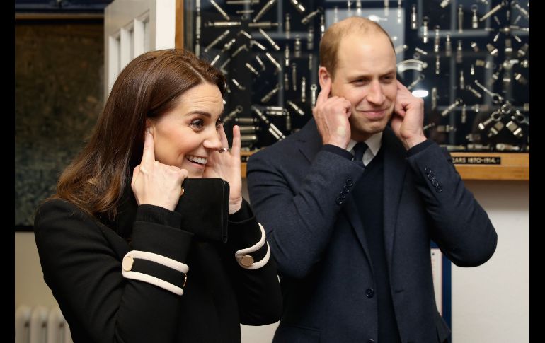 Los duques de Cambridge, Guillermo y Catalina, reaccionan al escuchar el sonido de un silbato de policía en su visita a la compañía Acme Whistles. AFP / C. Jackson
