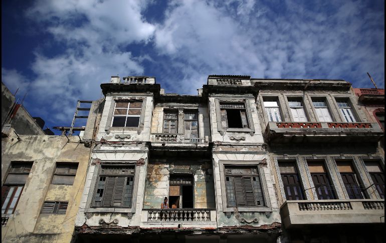 Una mujer observa desde el balcón de su casa en La Habana, Cuba. EFE/A. Ernesto