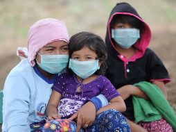 Una mujer indonesia y sus hijos usan mascarillas como medida de protección. AFP/S. Tumbelaka