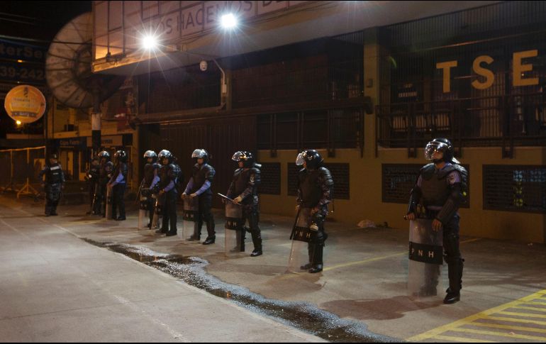 Policías resguardan las instalaciones del Tribunal Supremo Electoral, que no ha ofrecido cifras claras ante las declaraciones de triunfo de los candidatos. AP/M. Castillo