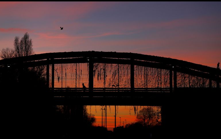 Un hombre corre por un puente en el parque Norte de Milán, Italia. AP/A. Calanni