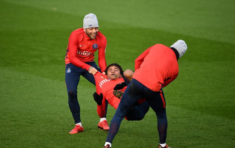 Dani Alves (i), del París Saint Germain, bromea con su compañero Christopher Nkunku (c) durante un entrenamiento del equipo en Saint Germain en Laye, Francia. AFP/F. Fife