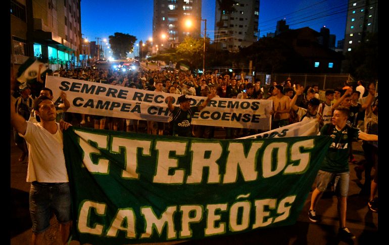 Asistentes a un homenaje a las víctimas del accidente aéreo del club de futbol Chapecoense de hace un año, realizado en el estadio de Chapecó, Brasil. AFP/N. Almeida