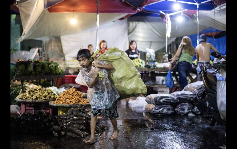 Un joven en Manila, Filipinas, recolecta botellas de plástico usadas para venderlas en el mercado Divisoria. AFP/N. Celis