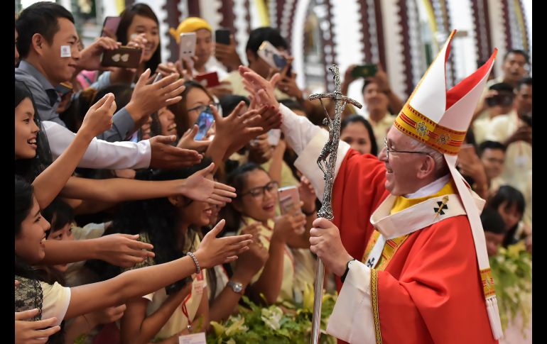 El Papa Francisco saluda a fieles a su llegada a celebrar una misa con jóvenes en la catedral de Rangún, Birmania. AP/L'Osservatore Romano
