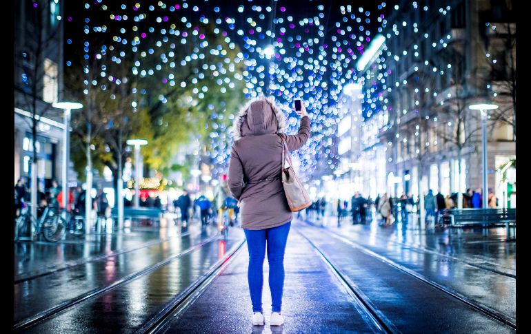Una mujer fotografía el alumbrado navideño de la ciudad suiza de Zúrich. EFE/C.Merz